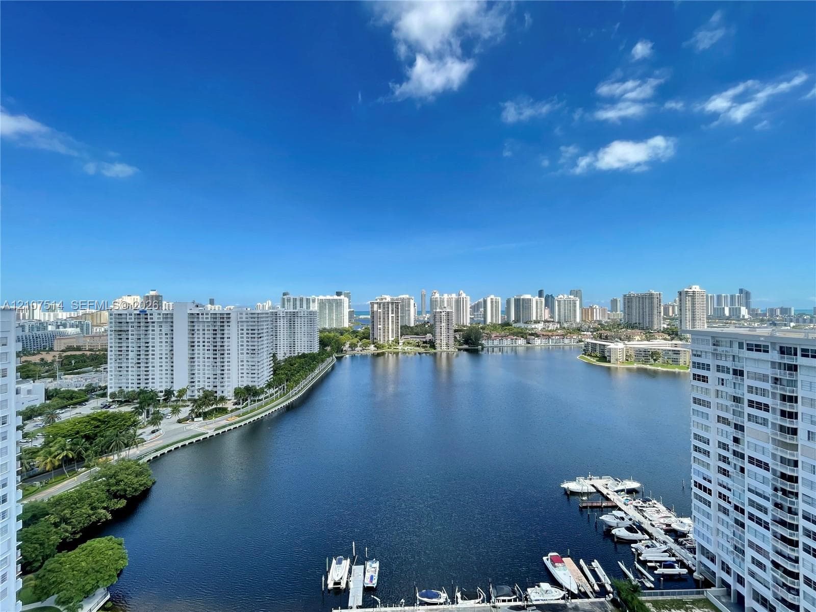 Panoramic water perspective featuring a marina with docking slips and a distant urban skyline