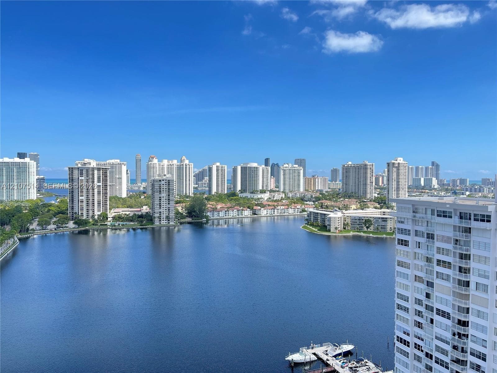 Panoramic water frontage, high-rise urban skyline, and deep-water boat dockage