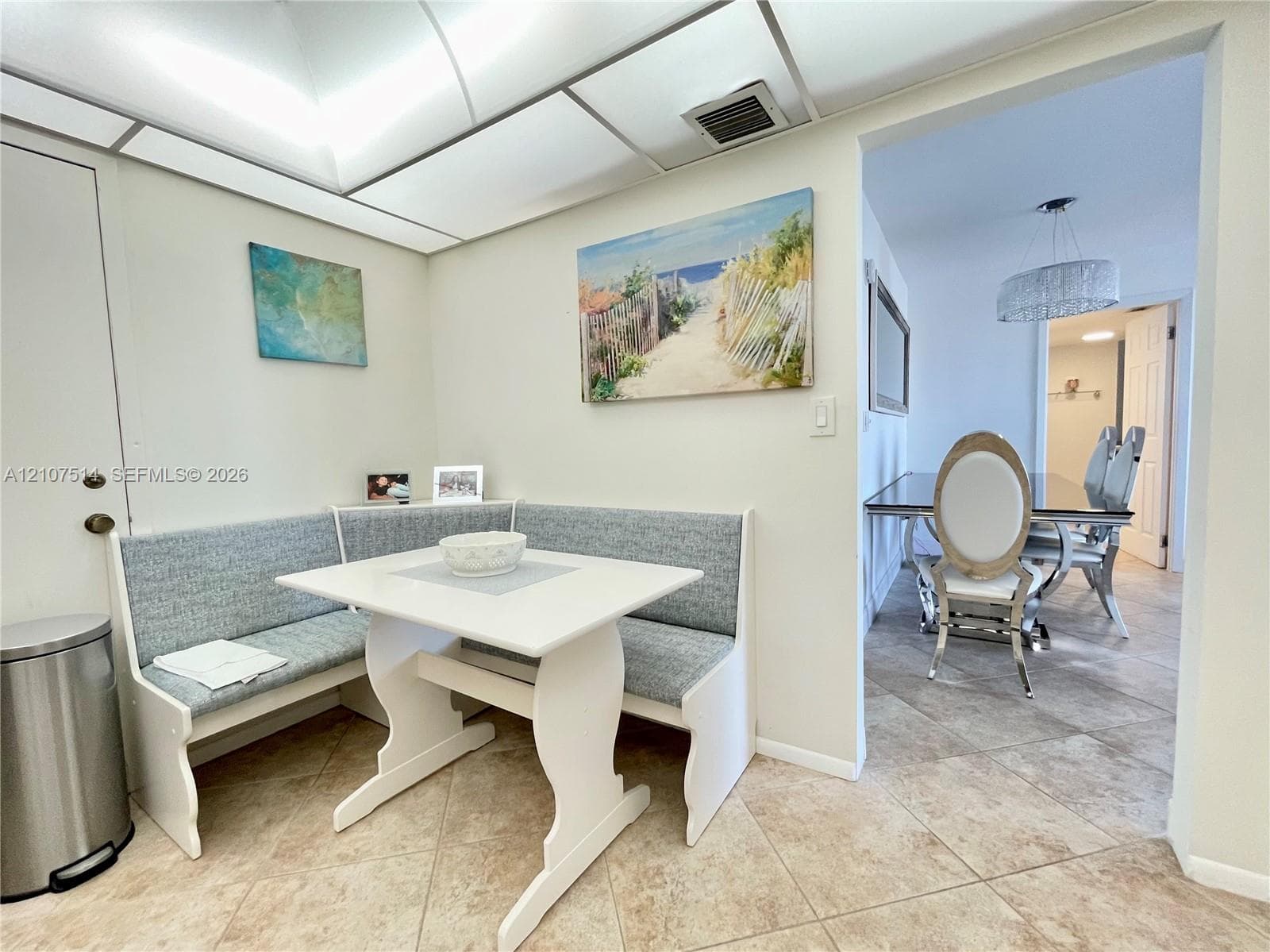 Built-in corner bench seating with neutral upholstery and tile flooring