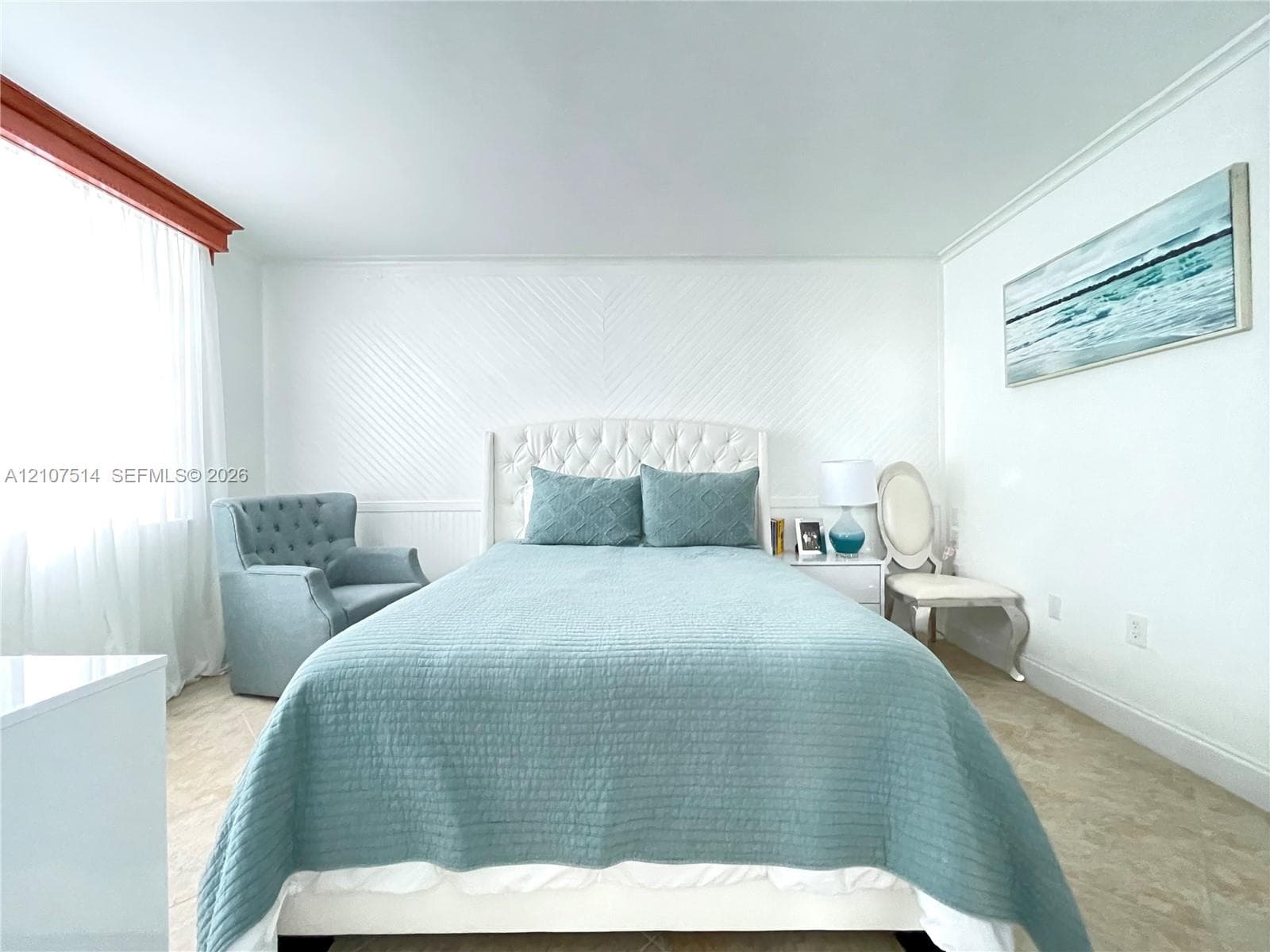 Room featuring chevron-patterned wainscoting, neutral tile flooring, and crown molding