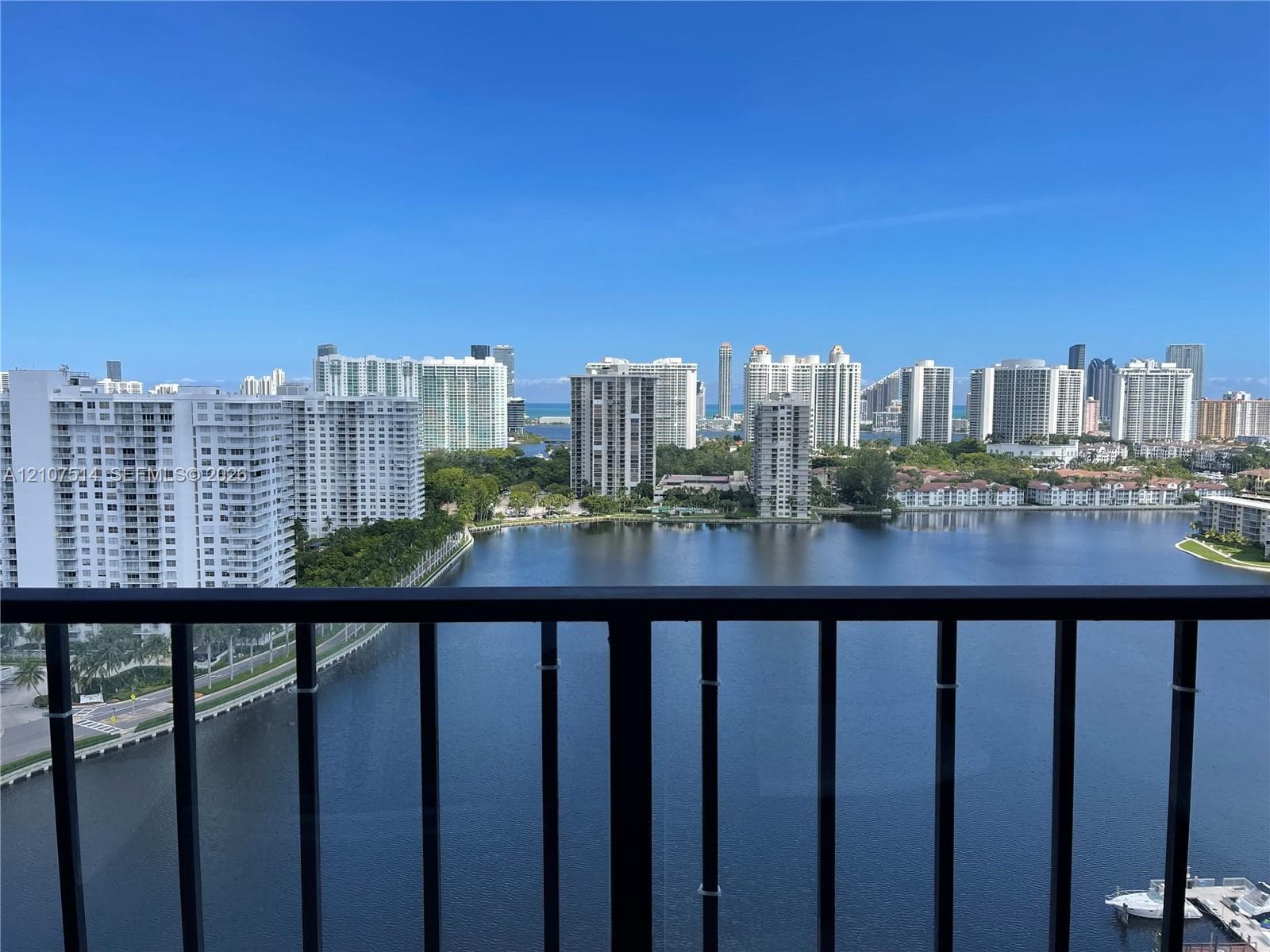 Balcony with black metal railing overlooking a waterfront and city skyline