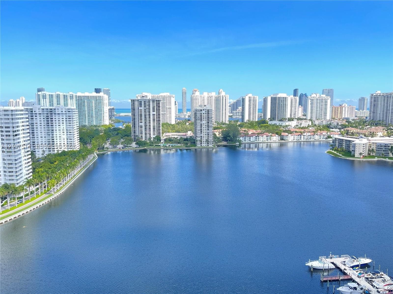 Panoramic water expanse with a private boat dock and surrounding coastal high-rise development