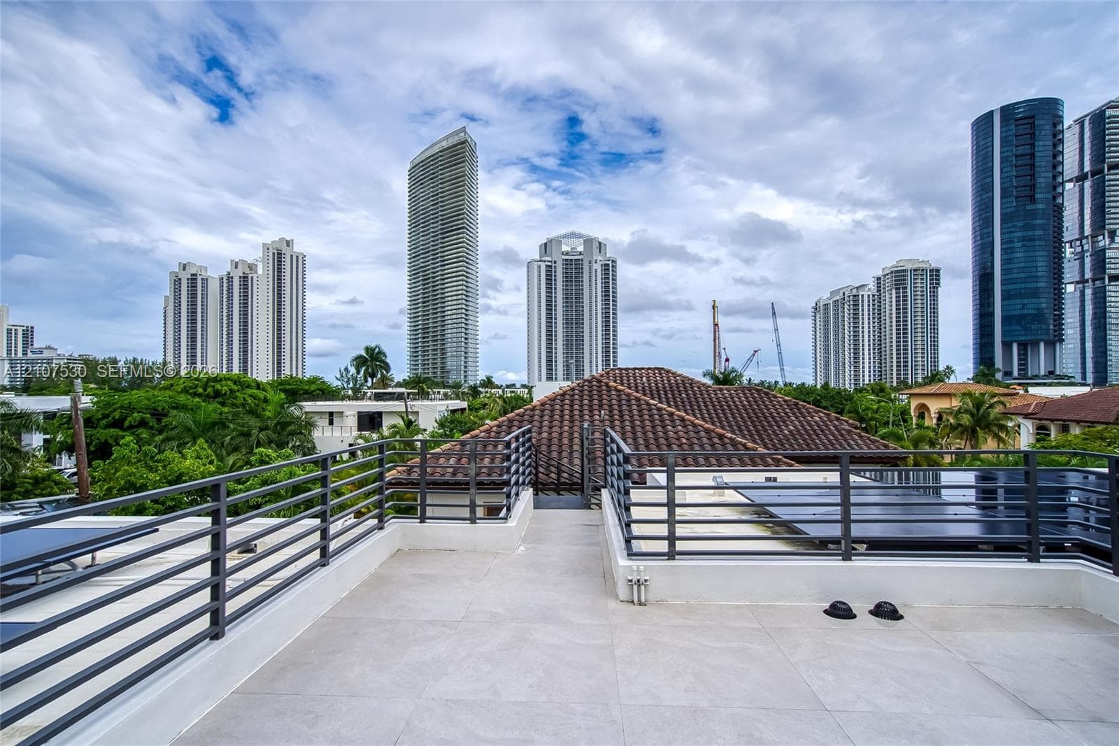 Rooftop terrace featuring large-format tile flooring and horizontal metal railings