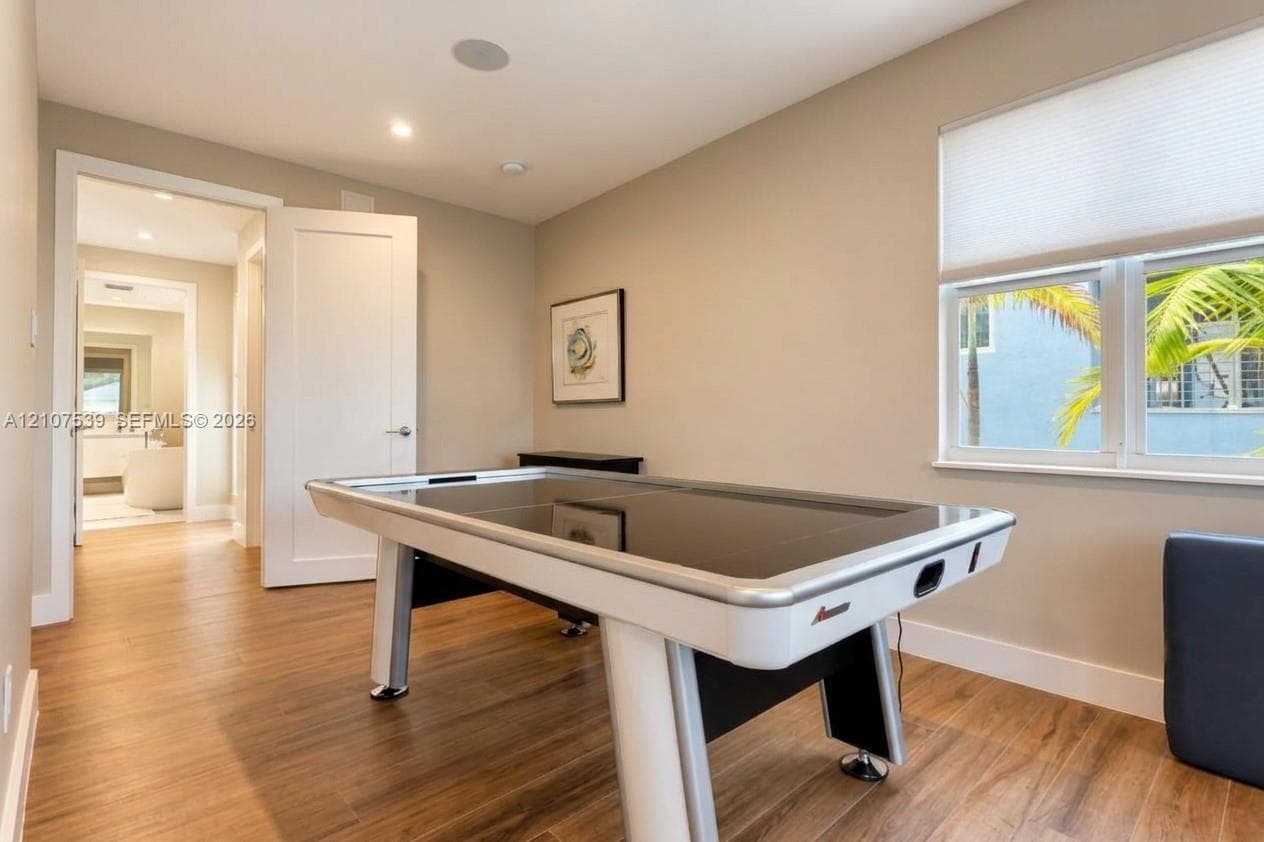 Wood-finish flooring, recessed lighting, multi-pane windows with integrated cellular shades, and neutral wall tones