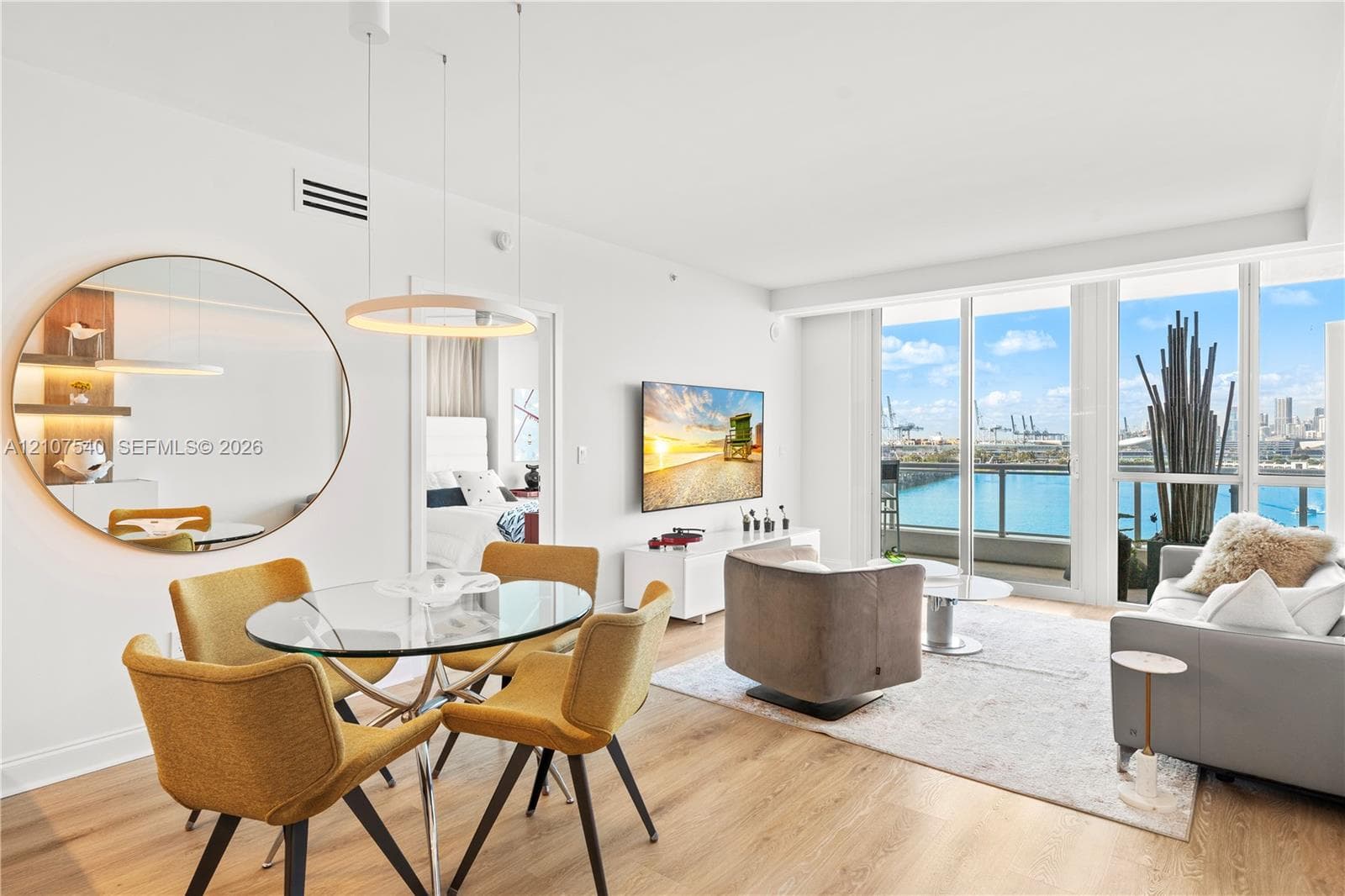 Open-concept professionally remodeled & appointed living space featuring top of the line Porcelanosa wood-finish flooring &  floor-to-ceiling windows with downtown Miami skyline views