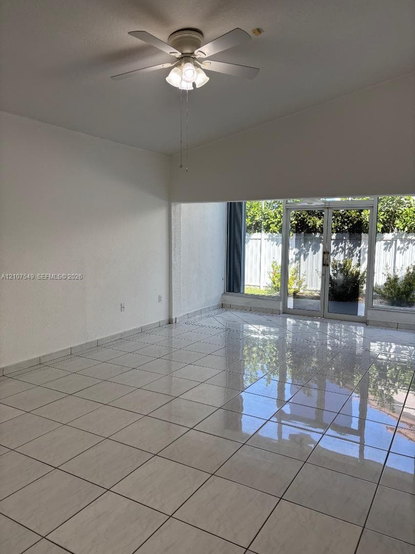 Interior space featuring high-gloss tile flooring, ceiling fan with integrated lighting, and full-height glass double doors
