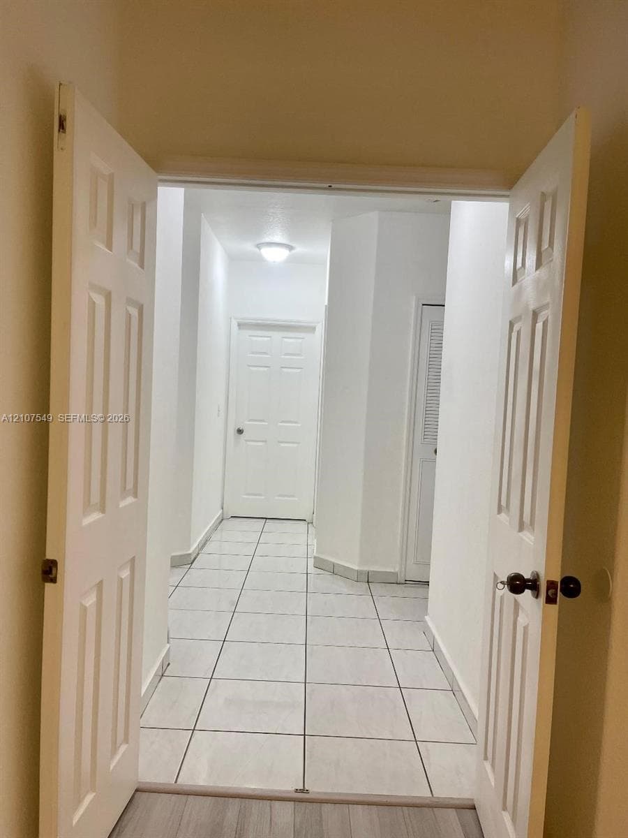 Interior space featuring ceramic tile flooring, six-panel interior doors, and a louvered closet door