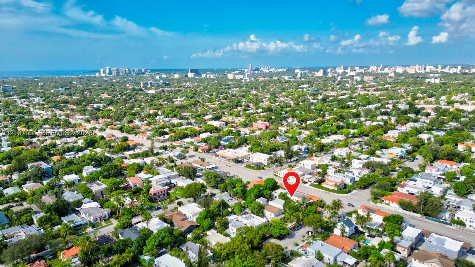 Aerial perspective highlighting a residential location featuring mature trees, surrounding foliage, and proximity to the coastline