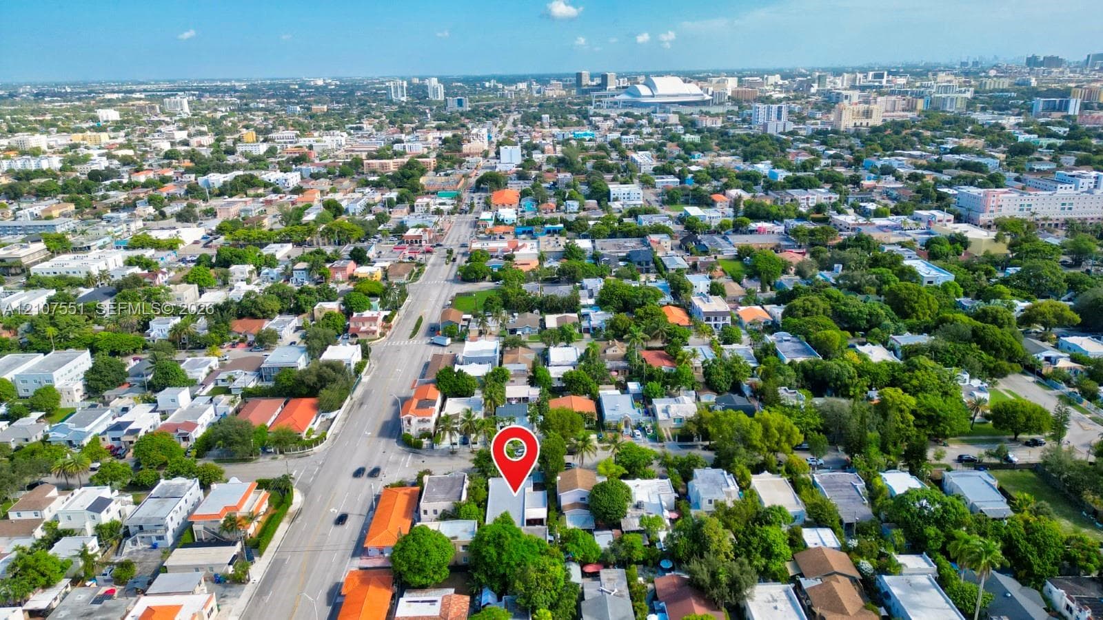 Aerial perspective of urban setting featuring dense residential infrastructure, mature canopy trees, and proximity to major metropolitan development