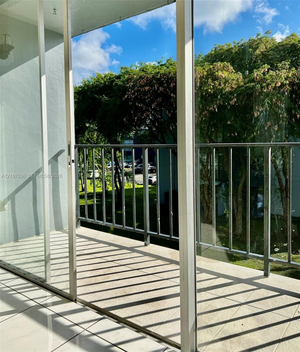 Private balcony featuring tile flooring, metal railings, and sliding glass door access