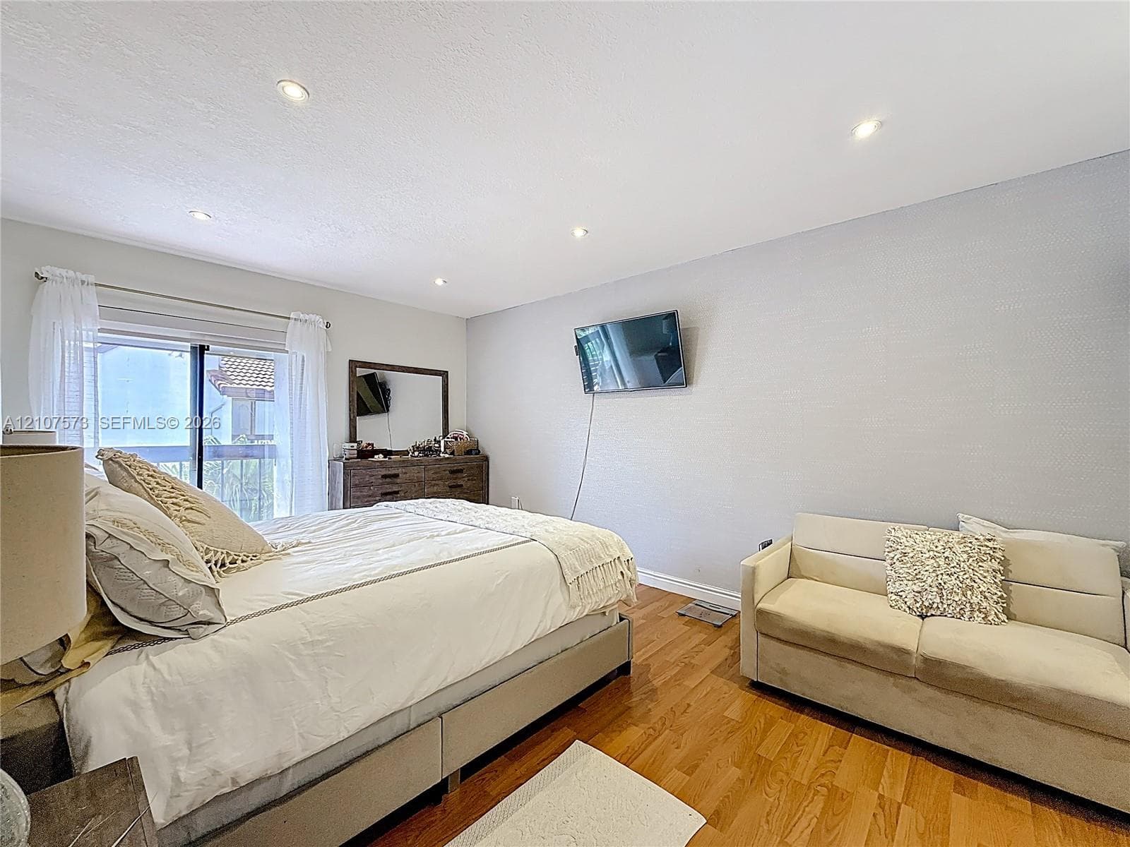 Wood-finish flooring, recessed ceiling lighting, and sliding glass doors with exterior access