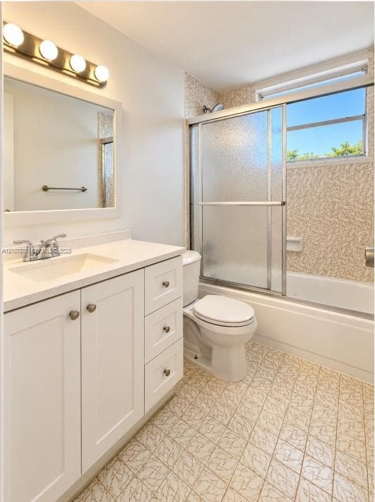 Bathroom featuring a vanity with integrated sink and storage cabinetry, four-light wall-mounted fixture, framed mirror, and a tub-shower combination with sliding glass doors