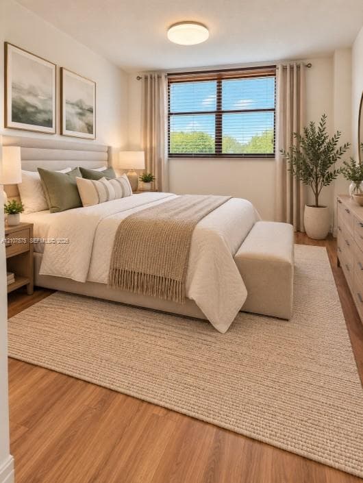 Wood-finish flooring, neutral wall tones, window with horizontal blinds, and a circular flush-mount ceiling light fixture