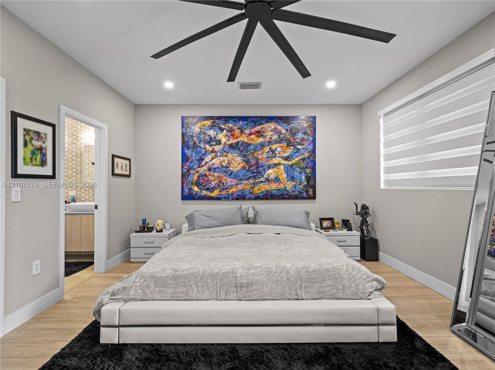 Neutral-toned interior featuring wood-finish flooring, a contemporary multi-blade ceiling fan, recessed lighting, and adjustable horizontal window blinds