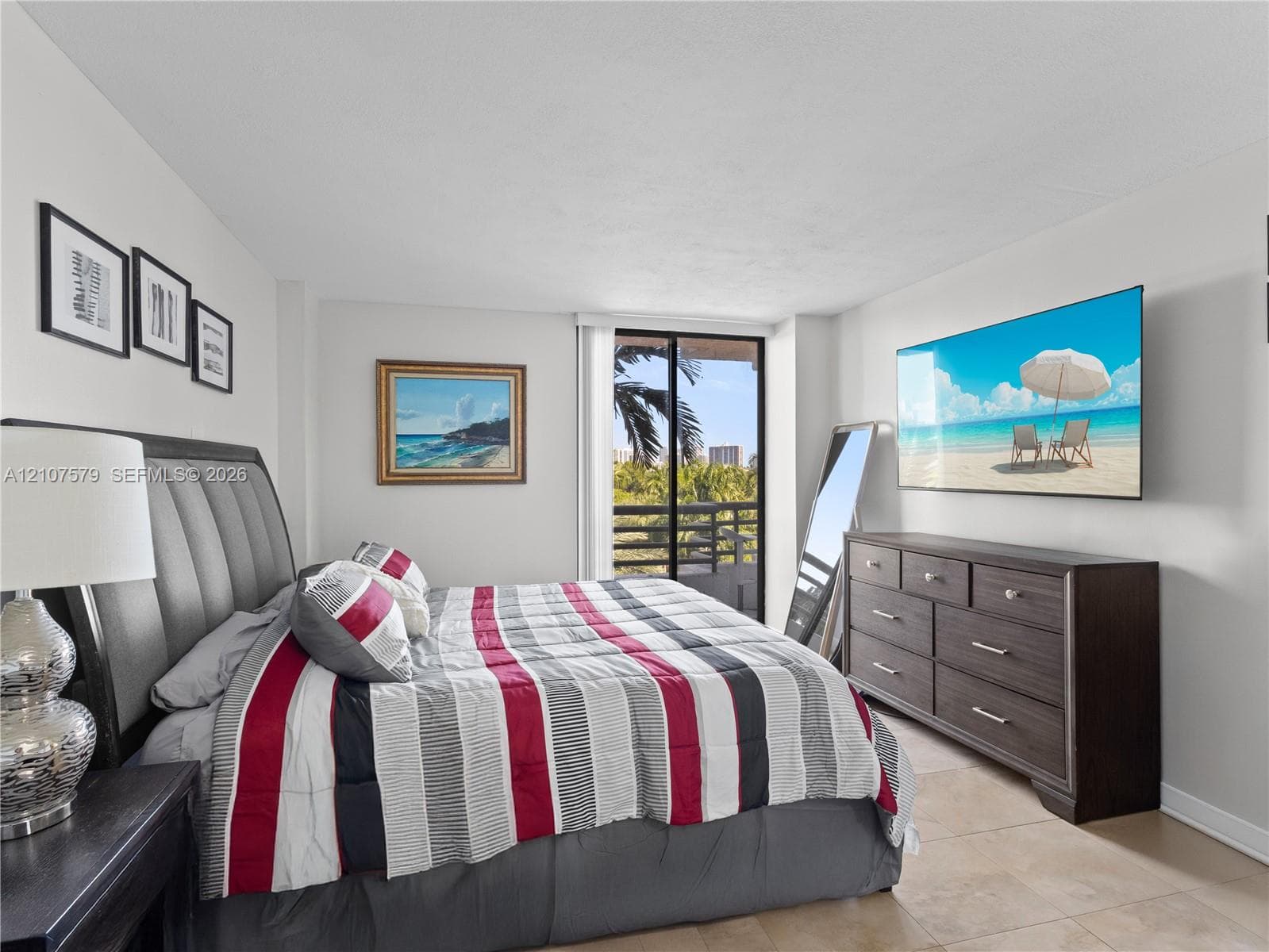 Neutral wall tones, tile flooring, and glass sliding doors providing access to a private balcony