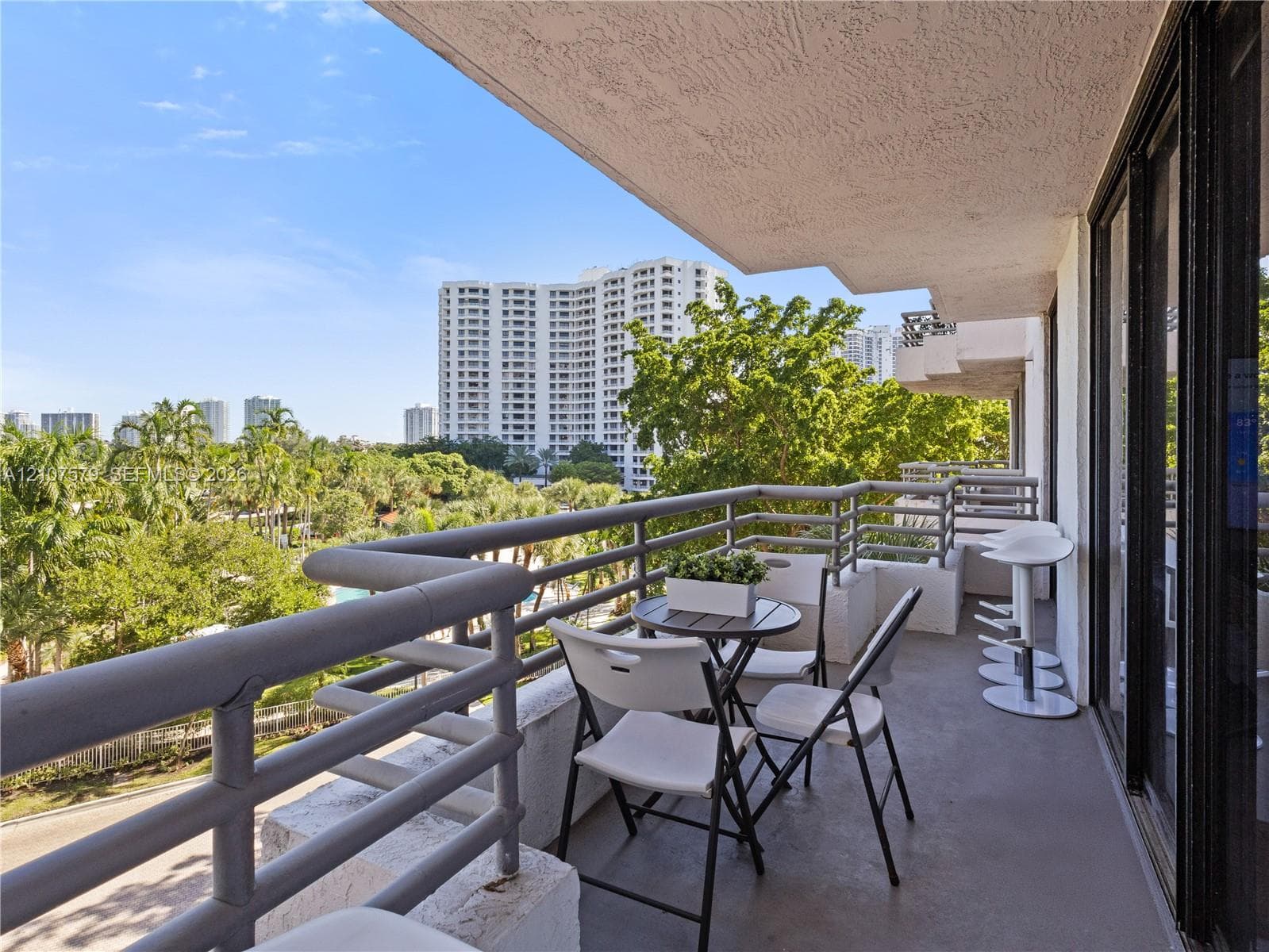 Covered balcony with grey concrete flooring and horizontal metal railing