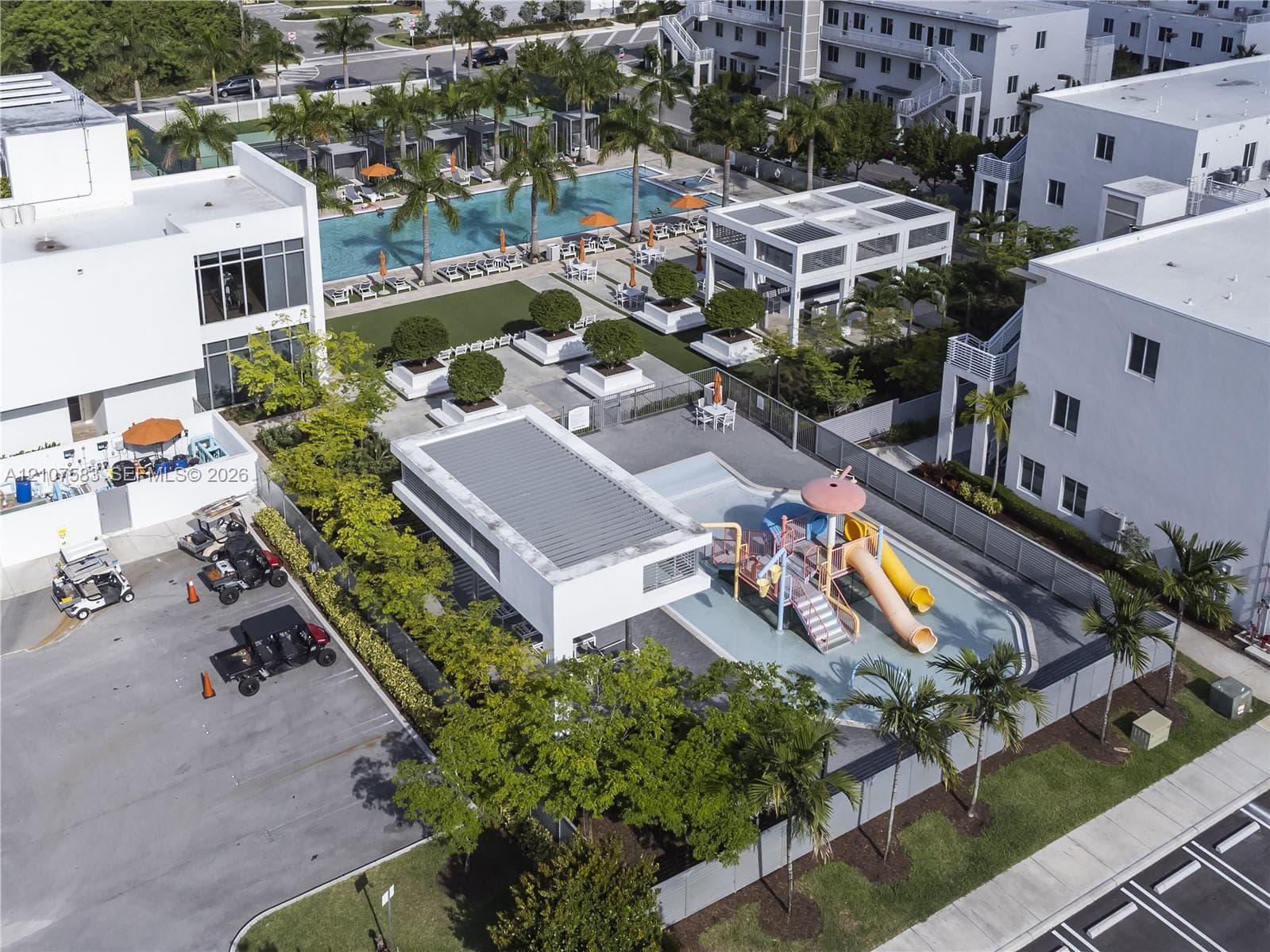 Community amenities featuring a swimming pool, covered pavilion, splash park with slides, and manicured landscaping