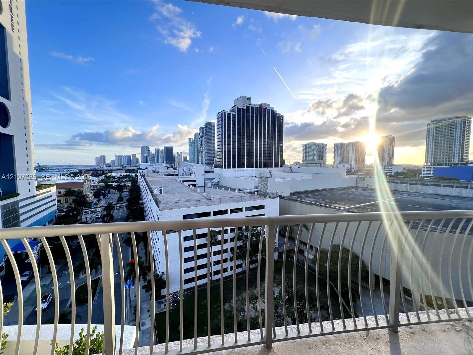 Private balcony featuring a curved metal railing and panoramic city skyline scenery
