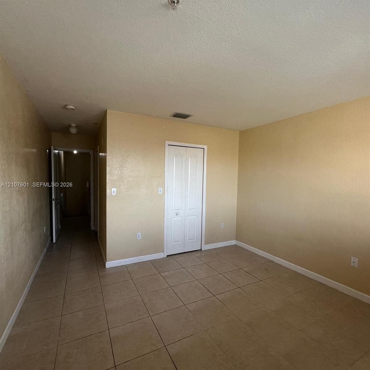 Room featuring ceramic tile flooring, neutral wall finish, and a white bi-fold closet door