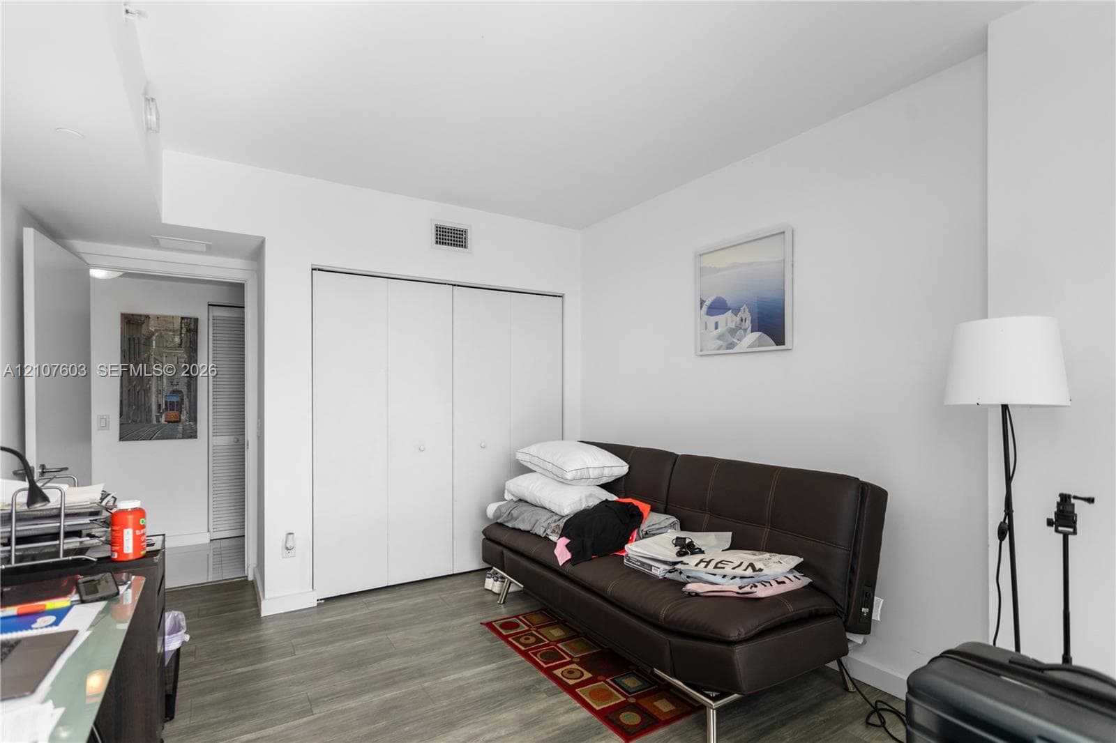 Neutral interior space featuring wood-finish flooring and floor-to-ceiling bi-fold closet doors