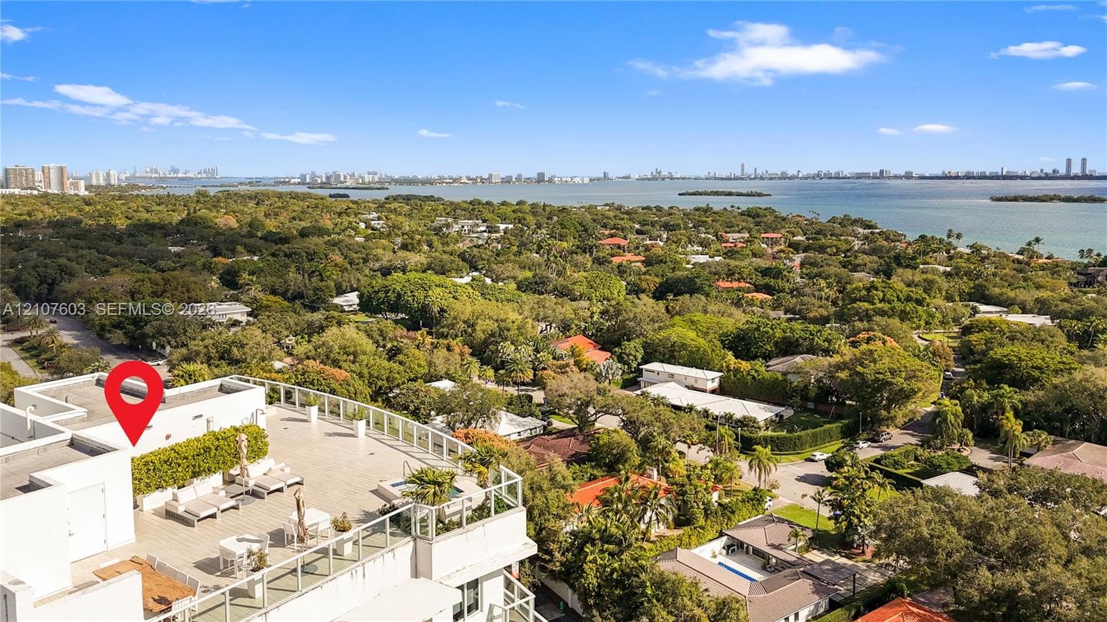 Expansive rooftop terrace featuring neutral tile flooring, glass perimeter railings, and a built-in spa