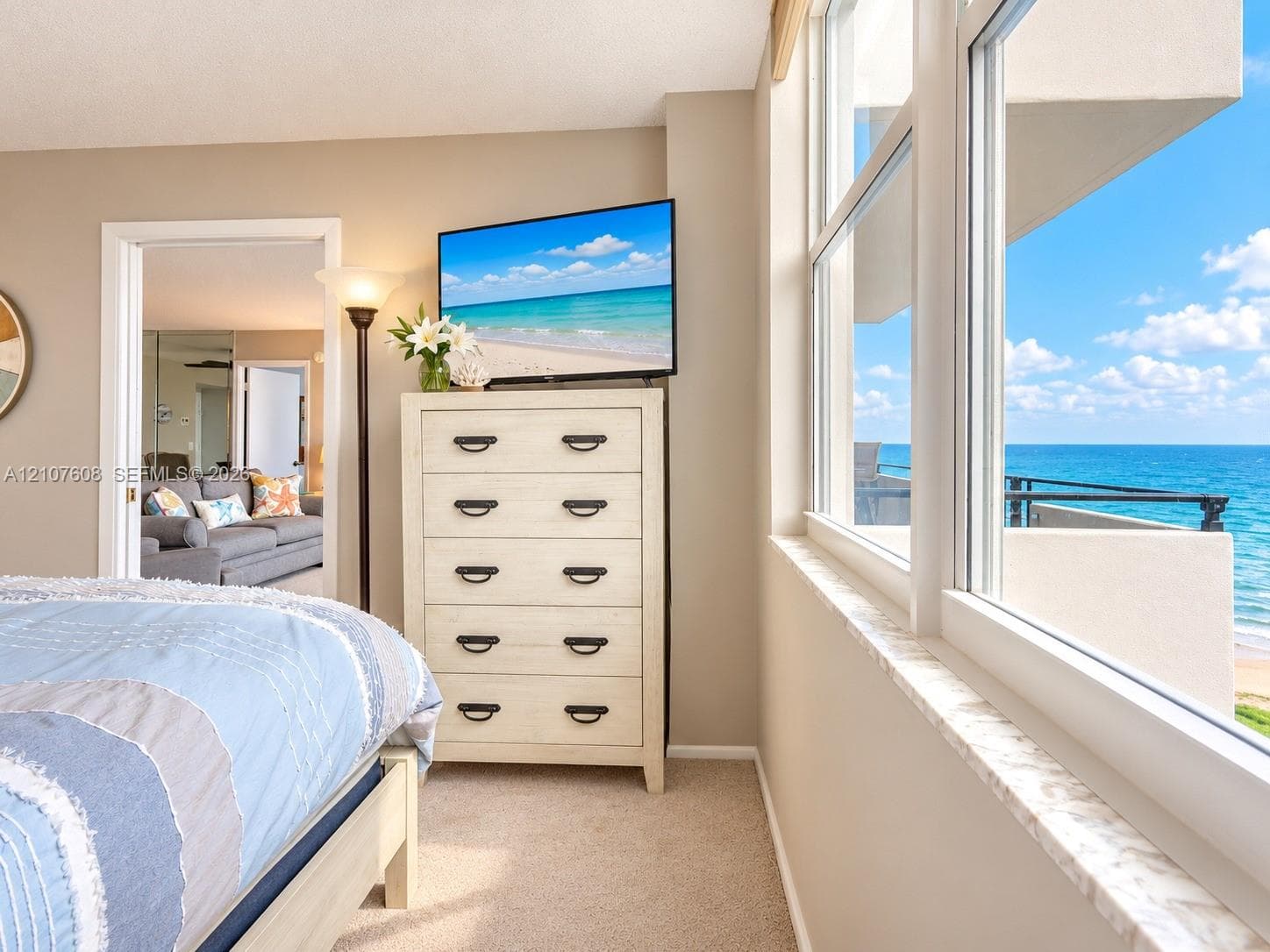 Expansive windows featuring a marble sill, neutral carpeting, and an open-air balcony