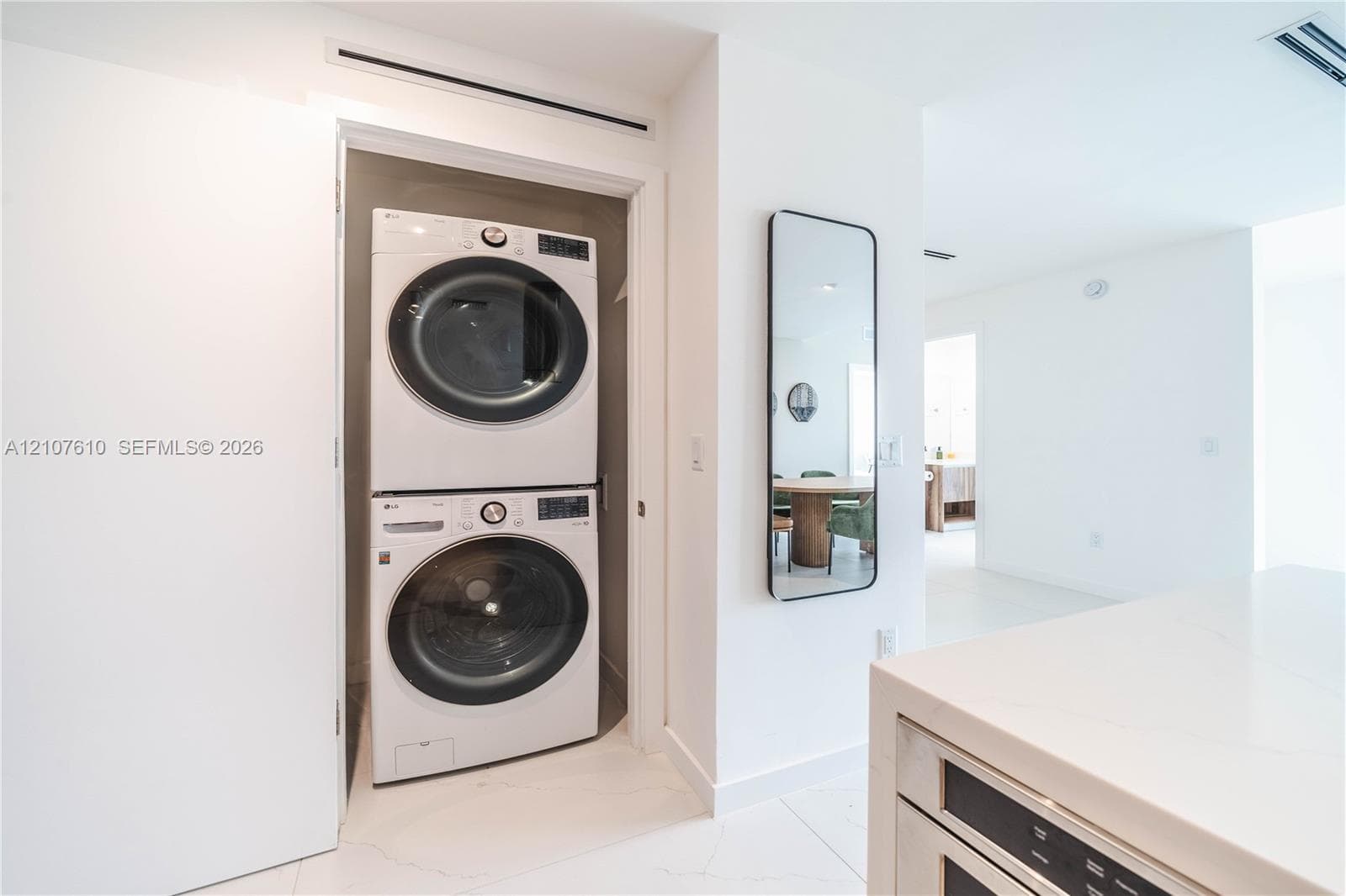 Laundry closet featuring stacked high-efficiency washer and dryer units