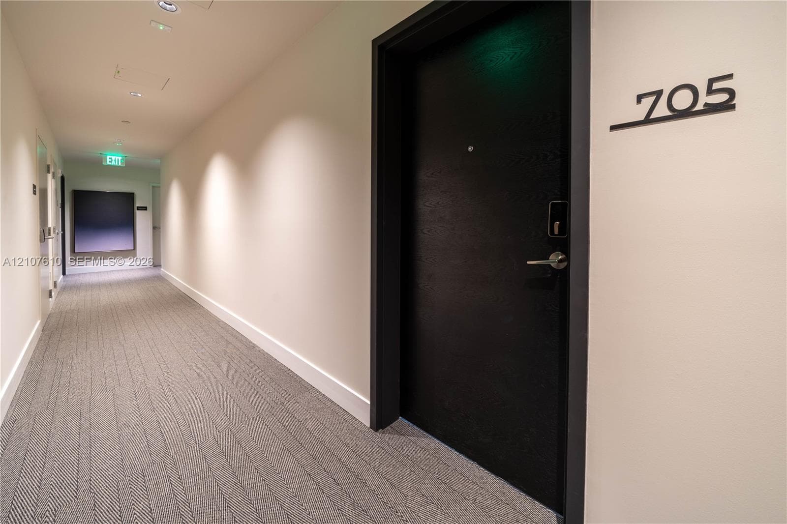 Solid core entry door with textured black finish, integrated electronic deadbolt, and contemporary metal hardware