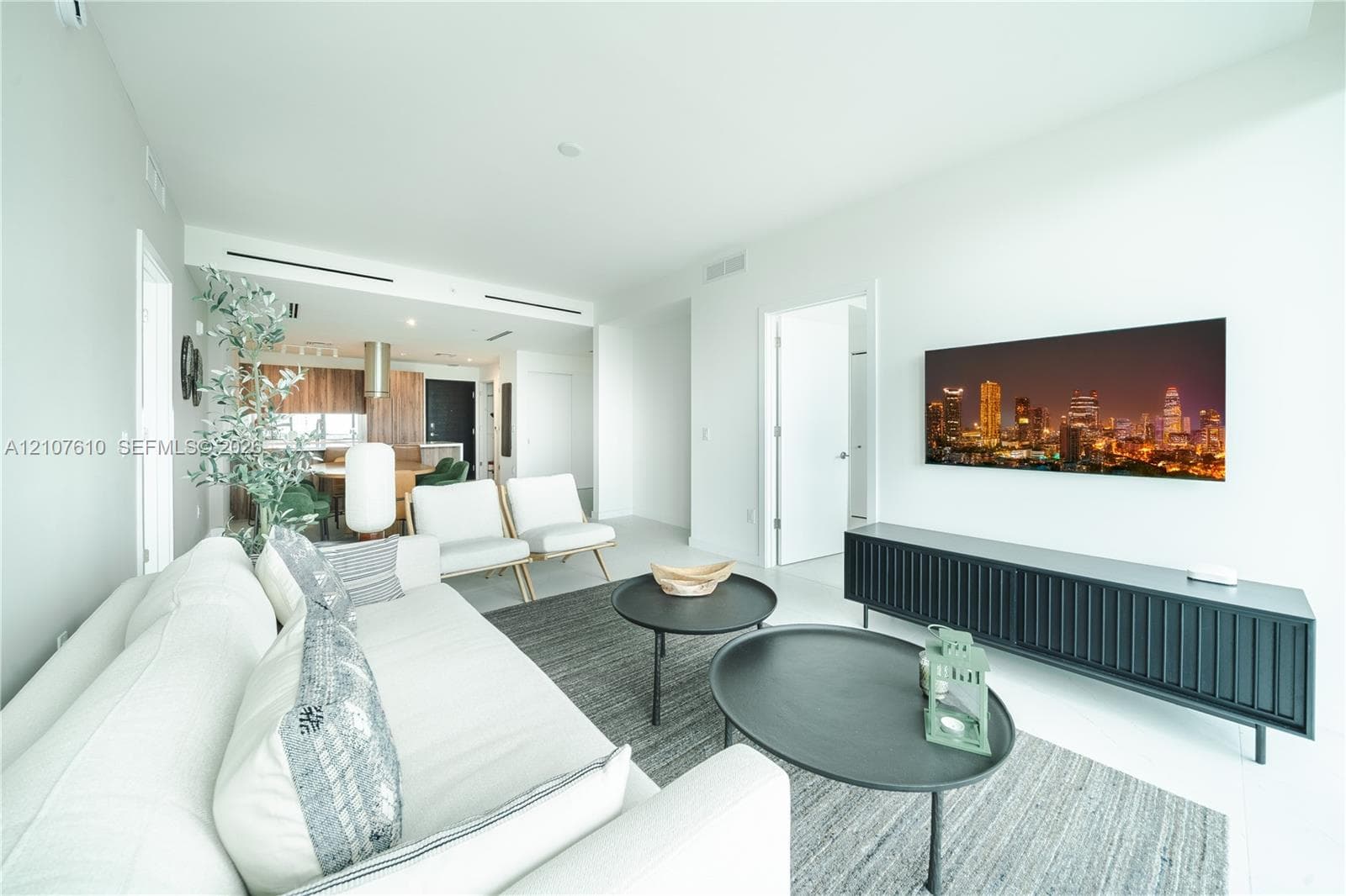 Open-concept interior featuring smooth white walls, recessed ceiling lighting, light-toned flooring, and integrated linear HVAC diffusers