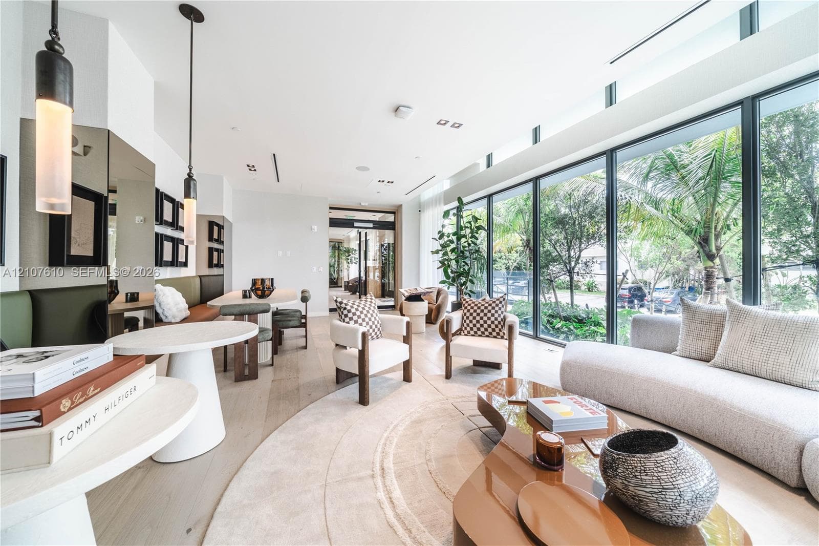 Open-concept interior featuring floor-to-ceiling windows, wood-finish flooring, recessed lighting, and dual cylindrical pendant fixtures