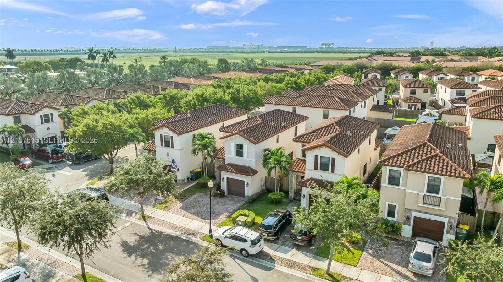 Two-story residence featuring a tile roof, light-toned stucco exterior, attached garage, and paved driveway