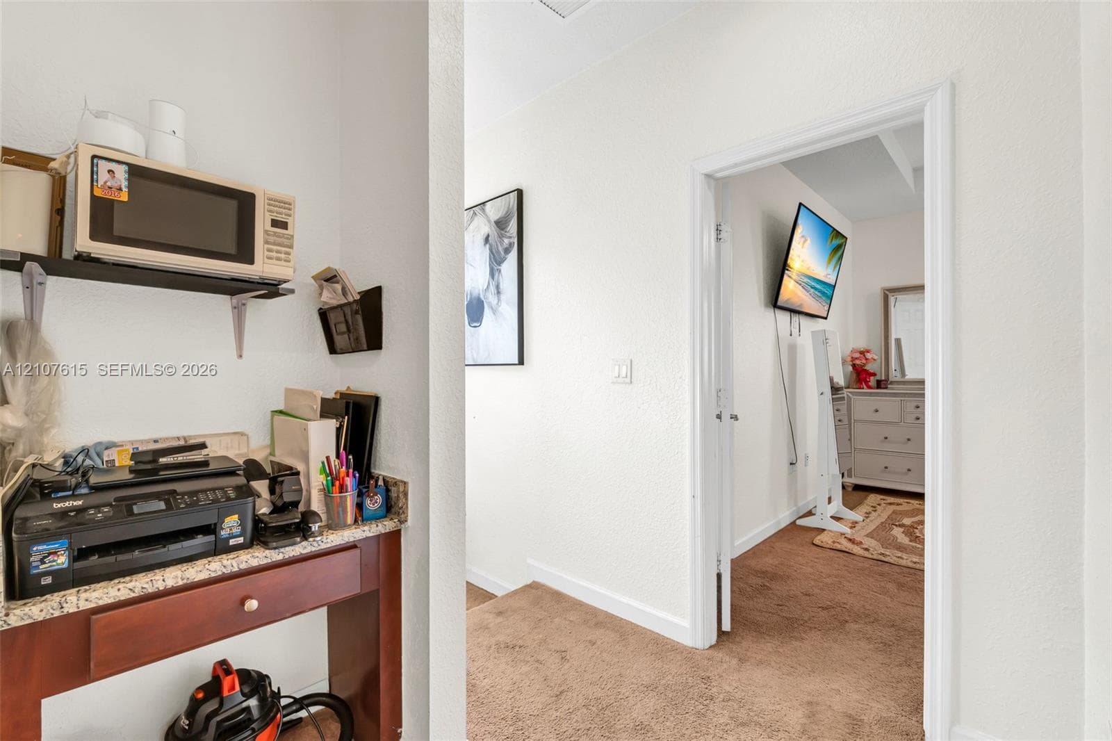 Built-in wall-mounted shelf and stone-finish countertop desk with a stained wood drawer