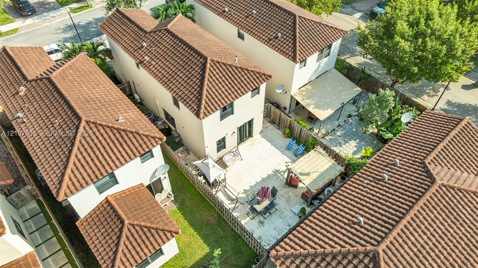 Multi-story stucco exterior featuring a terracotta tile roof and stone-paver patio