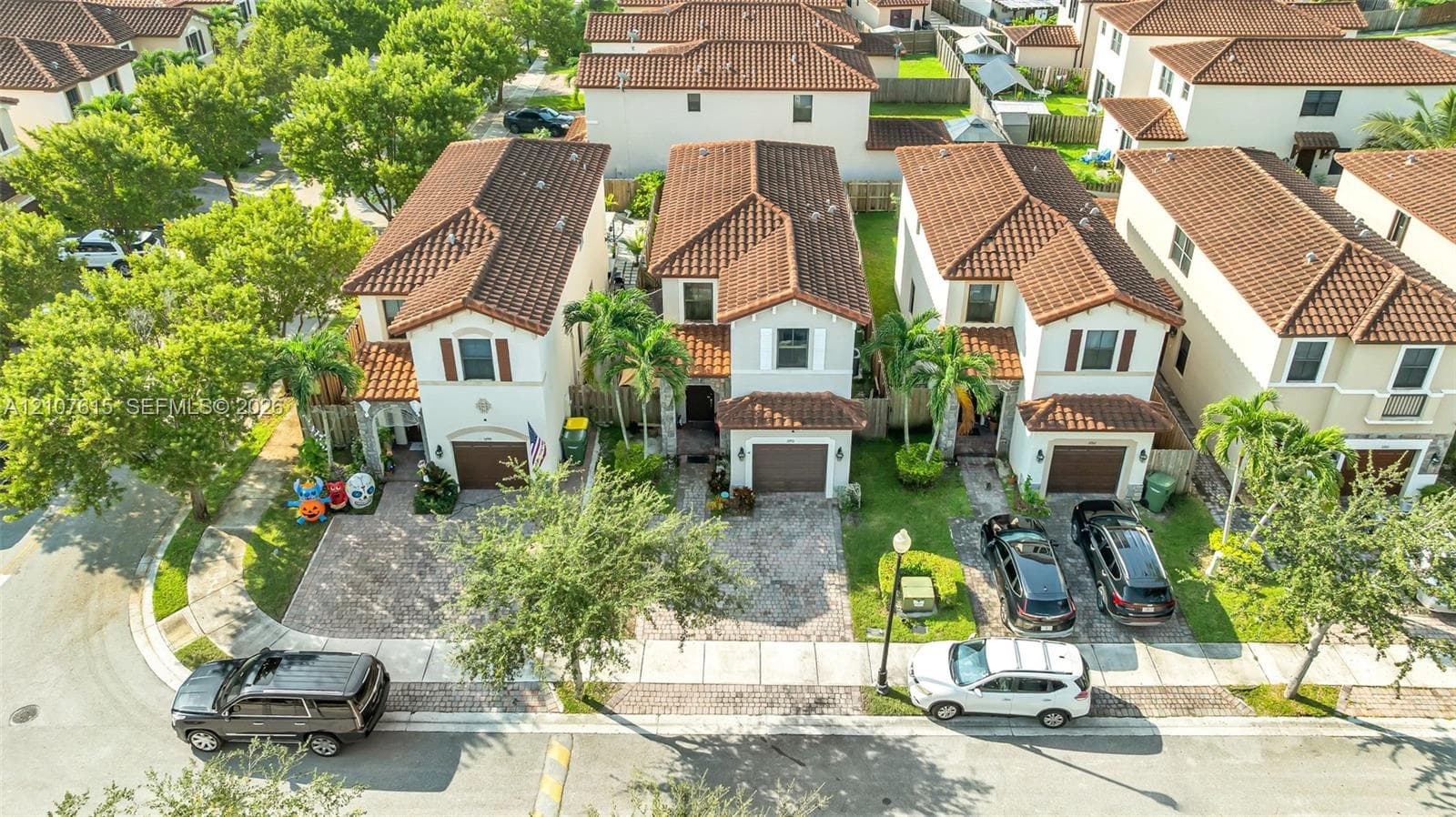 Multi-story residences featuring clay-tile roofing, stucco exteriors, attached garages, and paver driveways