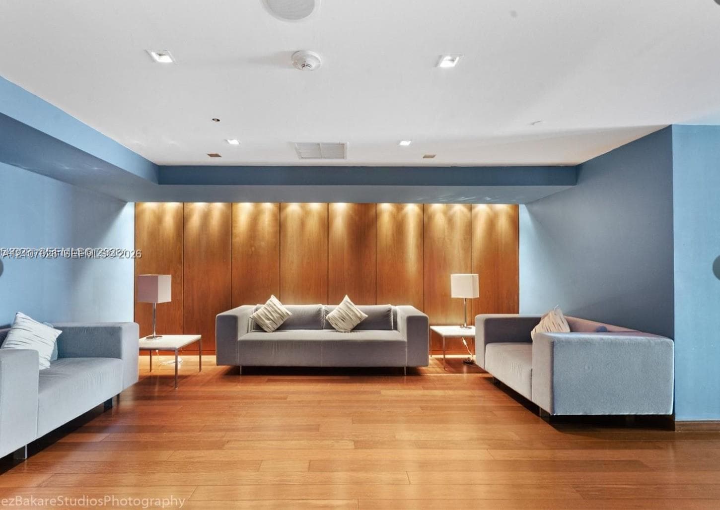 Interior space featuring wood-finish flooring, wood-paneled accent wall with recessed lighting, and recessed ceiling lighting