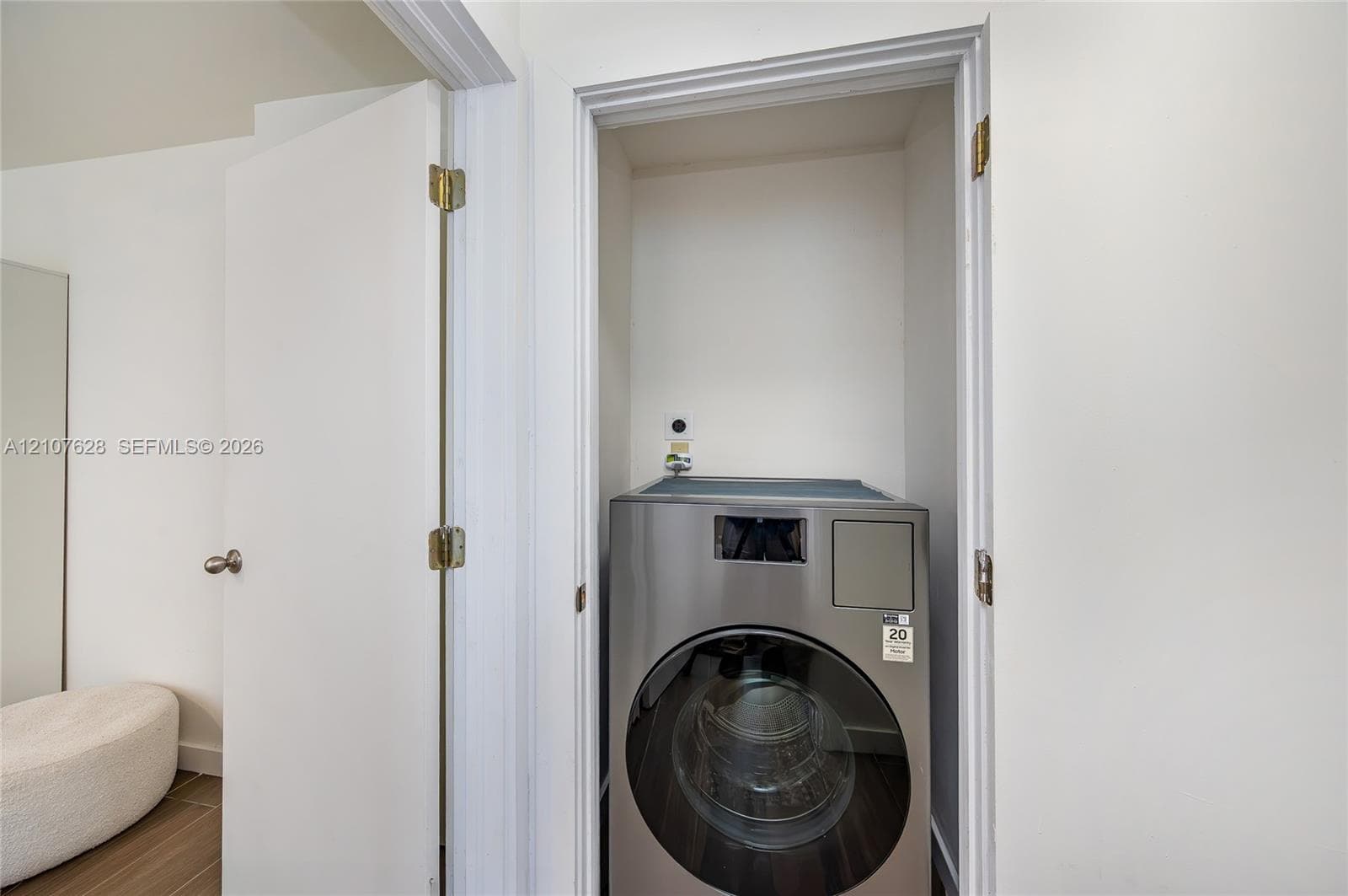 Laundry closet featuring a stainless steel front-load appliance and a dedicated water hookup