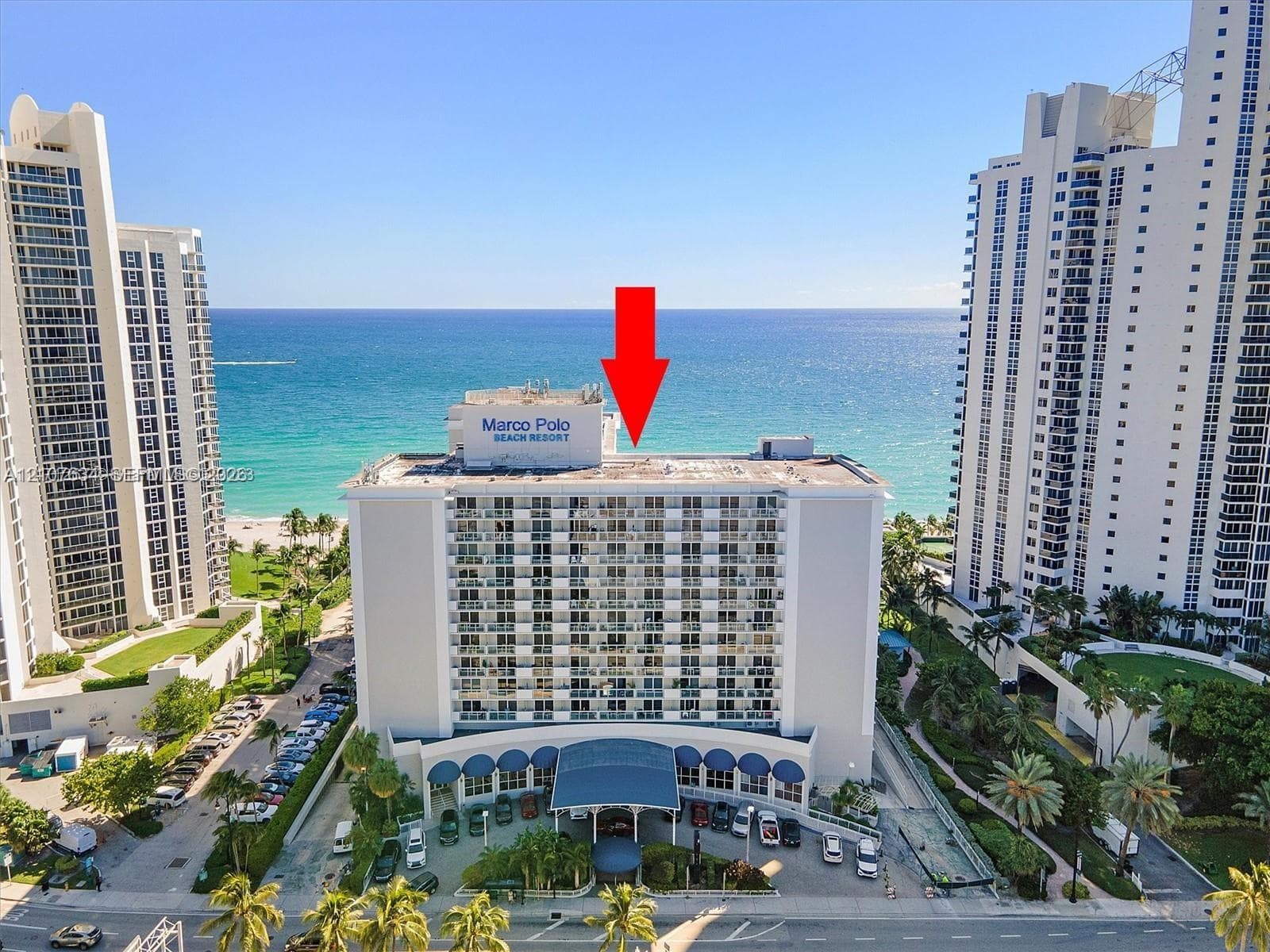 High-rise beachfront property featuring balconies, a covered entryway, and direct access to the coastline