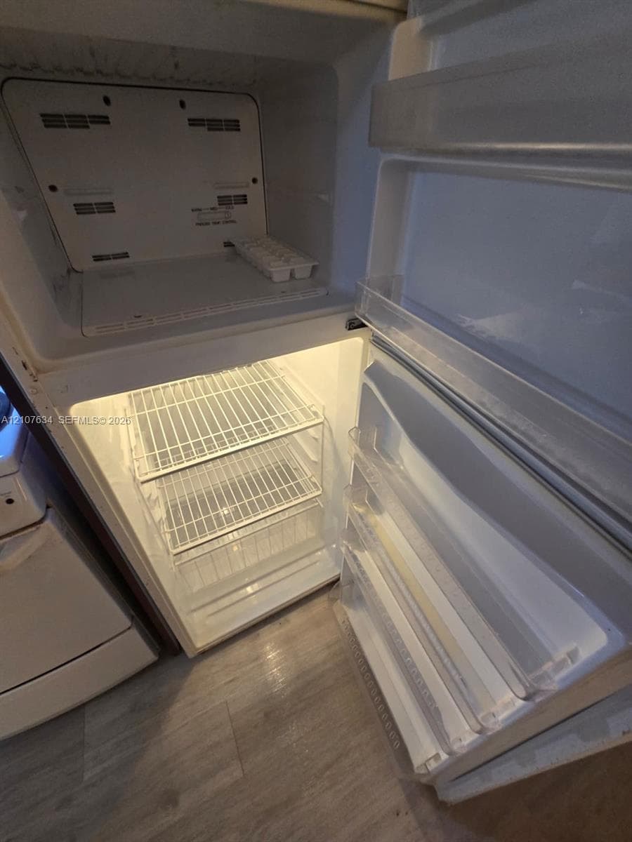 Top-mount refrigerator featuring wire shelving, door storage bins, and integrated interior lighting
