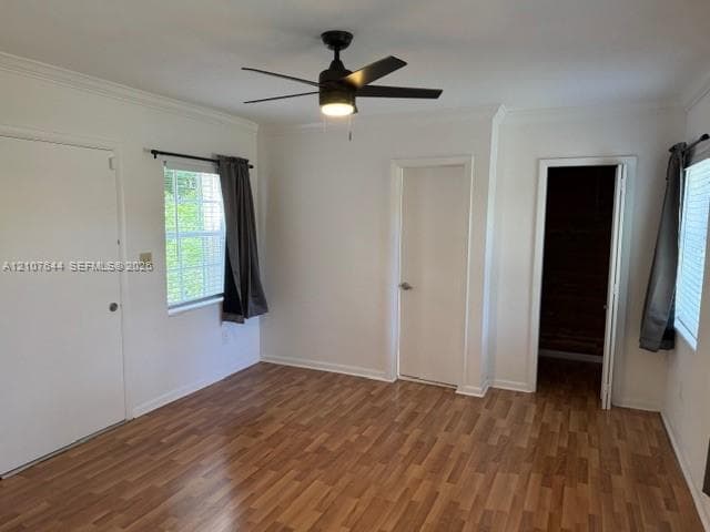 Wood-finish flooring, matte black ceiling fan with integrated lighting, dual windows with multi-pane glazing, and interior doors with satin finish hardware