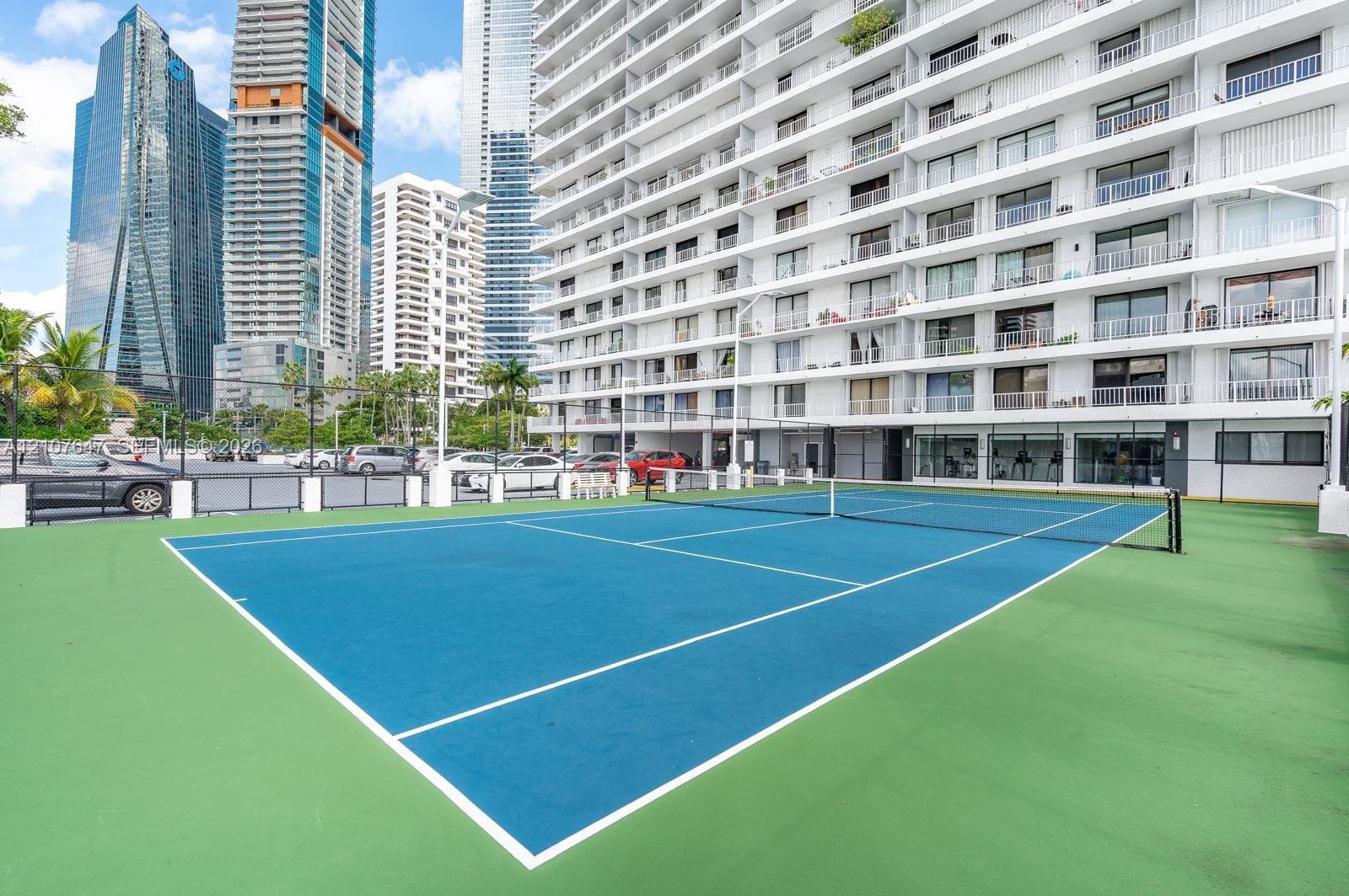 Hard-court tennis facility featuring perimeter fencing and court-marking lines