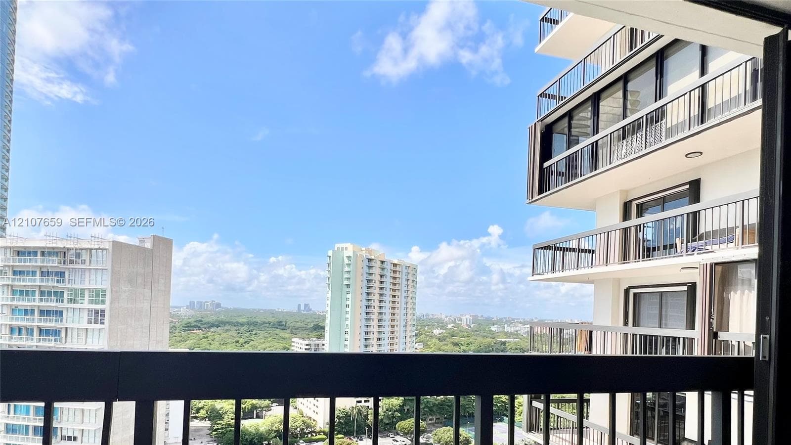 Private balcony featuring black metal railings and panoramic cityscape scenery