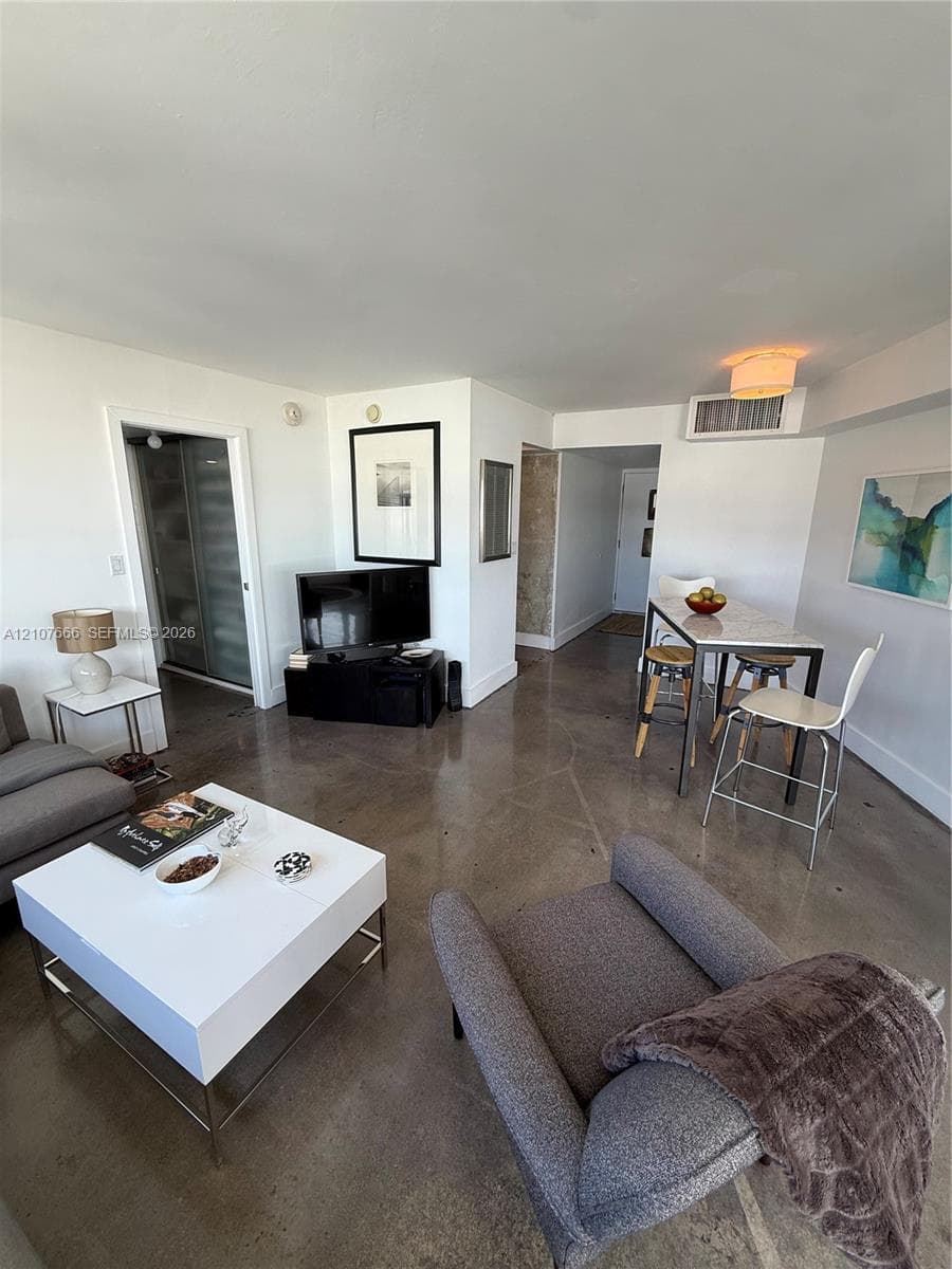 Polished concrete flooring throughout with neutral wall finishes and a flush-mount ceiling light fixture