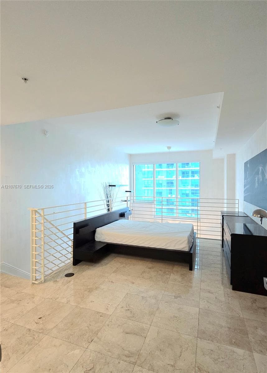 Large-format stone tile flooring, floor-to-ceiling glass windows, and white metal horizontal railing system