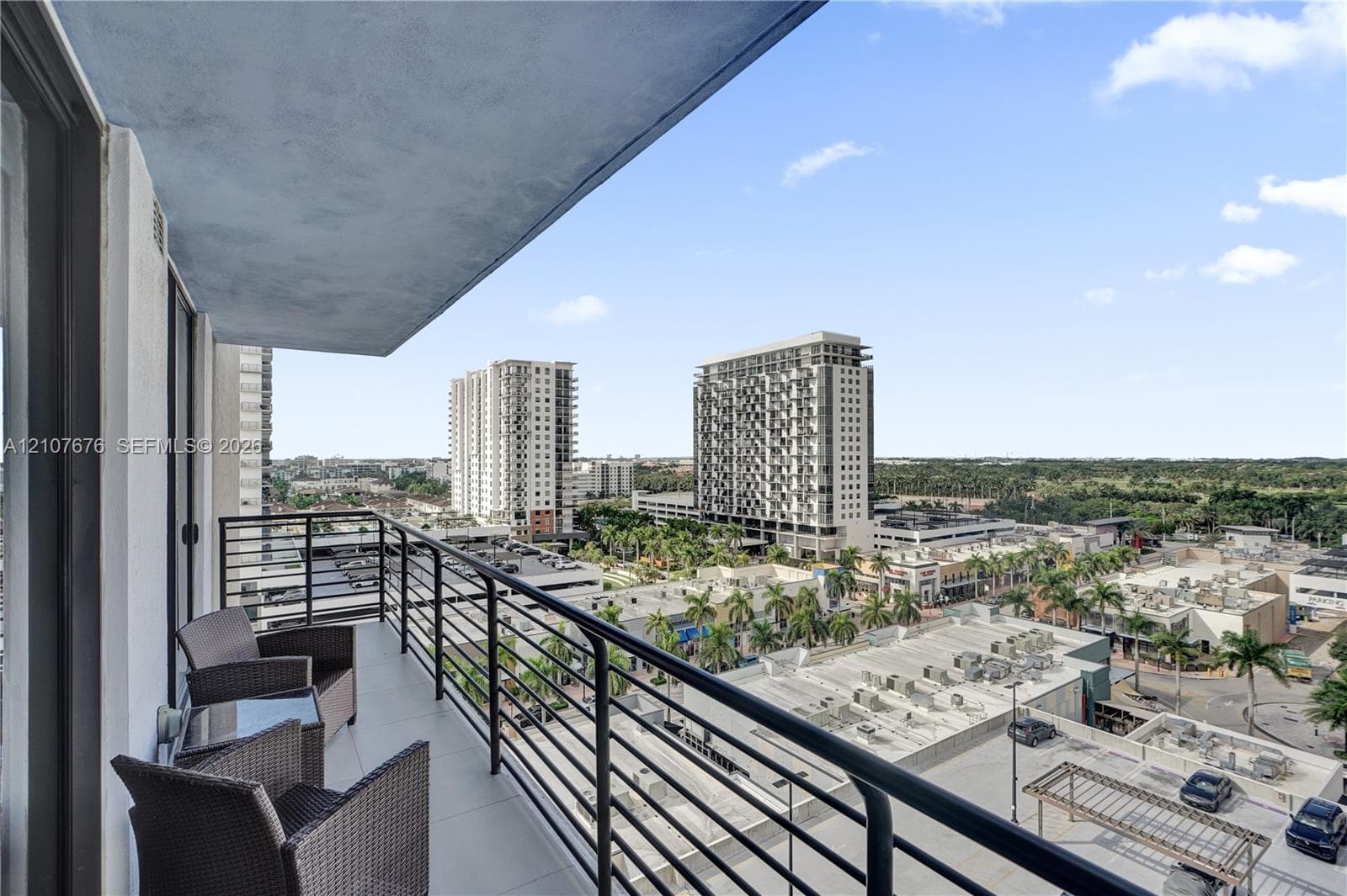 Covered balcony featuring concrete flooring and a black metal railing