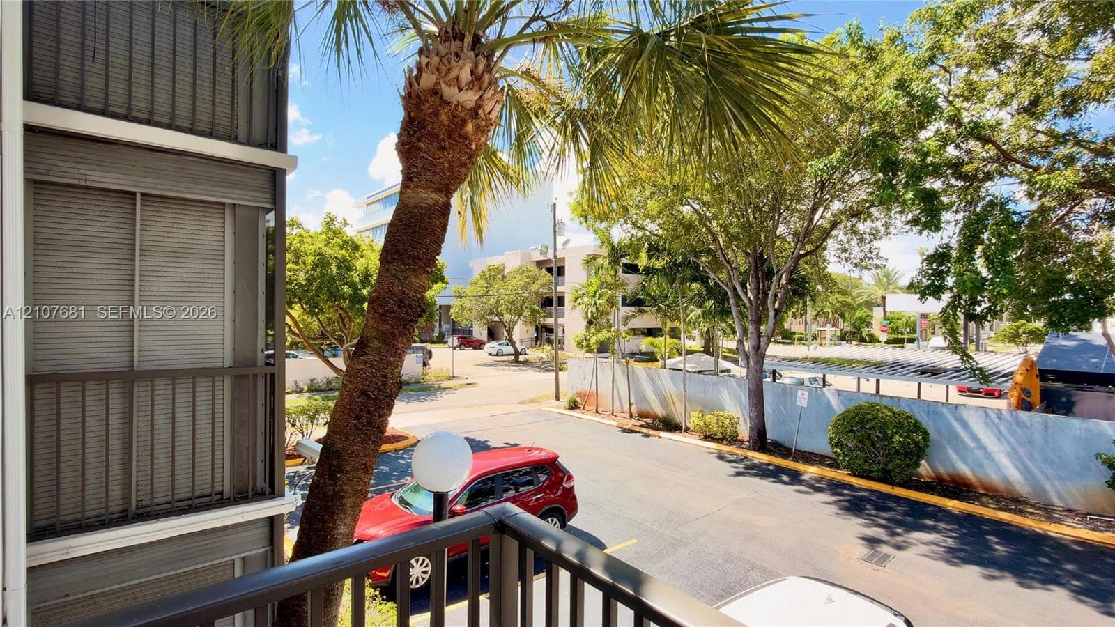 Private balcony featuring a metal railing and vertical privacy shutter