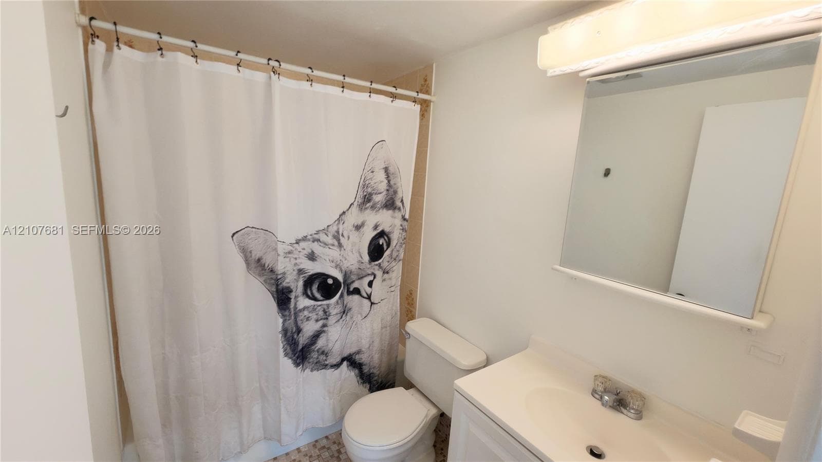 Bathroom featuring a white vanity cabinet, integrated sink with a chrome faucet, wall-mounted medicine cabinet, and a tub-shower combination
