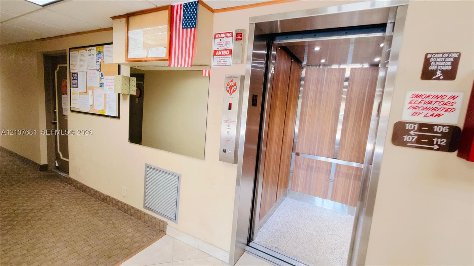 Elevator featuring brushed metal trim and wood-finish interior paneling