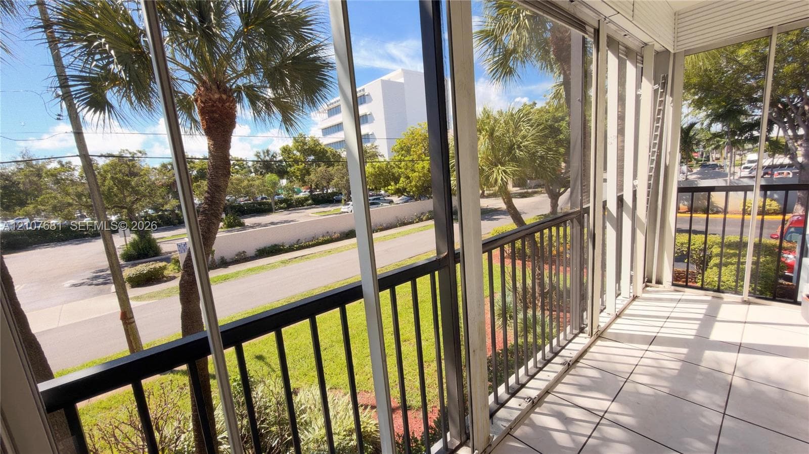 Screened-in balcony featuring tile flooring and metal railing