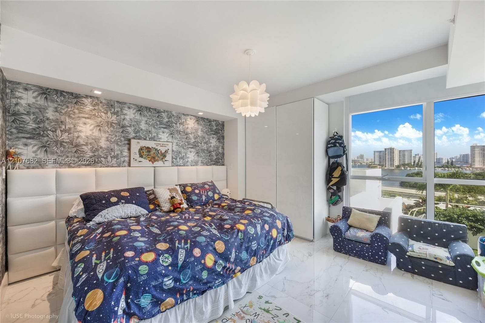 Floor-to-ceiling windows, built-in floor-to-ceiling cabinetry with high-gloss finish, custom upholstered wall paneling, and polished stone-finish flooring