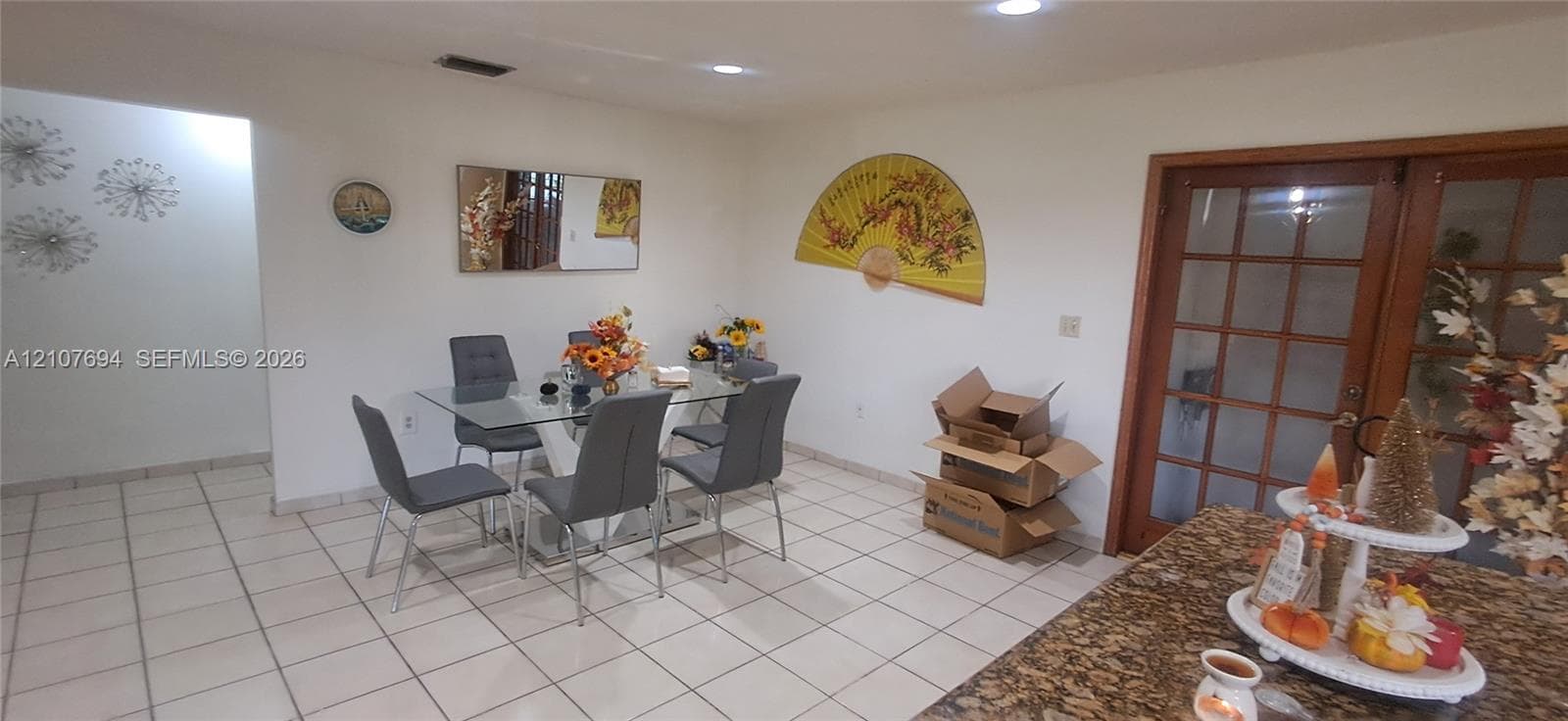 Ceramic tile flooring, recessed ceiling lighting, and wood-framed glass pane double doors